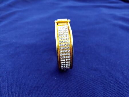golden diamond bangles isolated on blue background