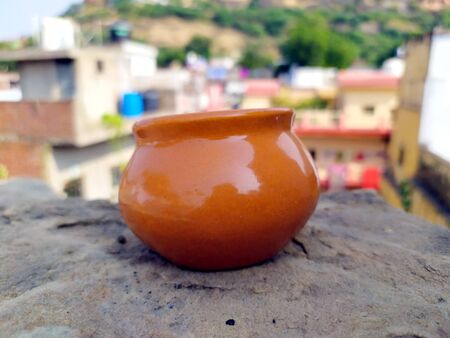 A BROWN COLOR CLAY POT PUT ON THE ROADの写真素材