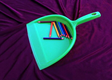 green garbage cleaner with color pencil isolated on brown backgroundの写真素材