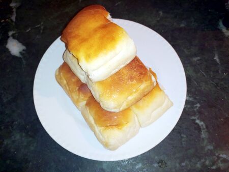 home made fresh bread put in a white plate on black stone background