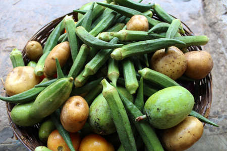 some fresh healthy vegetable put in a basket on stone backgroundの写真素材