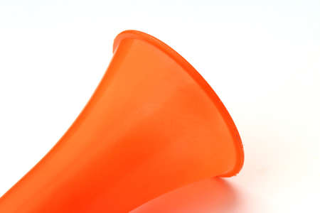 a orange color plastic vuvuzela horn isolated on white backgroundの写真素材