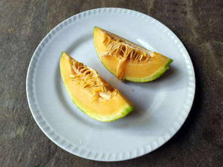 fresh healthy yellow fruit bite put in a white plateの写真素材