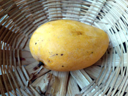 fresh sweet yellow mango put in a basketの写真素材