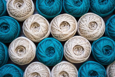 Nearby are many balls of knitting yarn for beige and turquoise.の写真素材