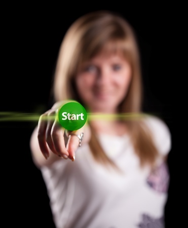 Woman pressing START button, background in bokeh