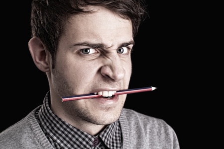 portrait of a young angry man with pencil の写真素材