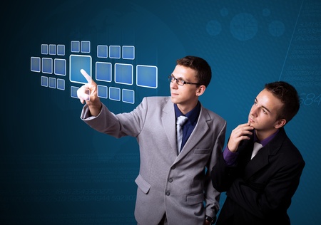 Businessman pressing high tech type of modern buttons on a virtual backgroundの写真素材