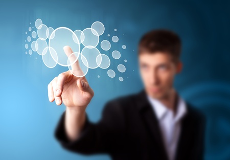 Businessman pressing high tech type of modern buttons on a virtual backgroundの写真素材