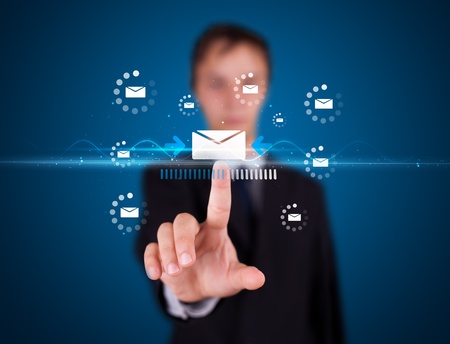 Businessman pressing messaging type of modern icons with virtual backgroundの写真素材
