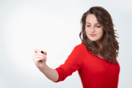 Young woman drawing on wihteboard with white copyspaceの写真素材