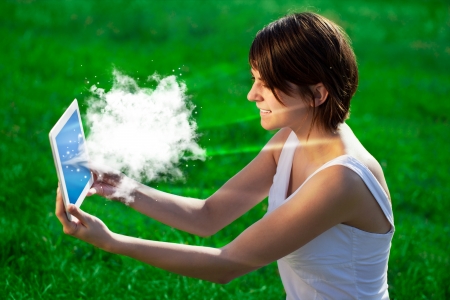 Young business woman looking at modern tablet with abstract cloudの写真素材