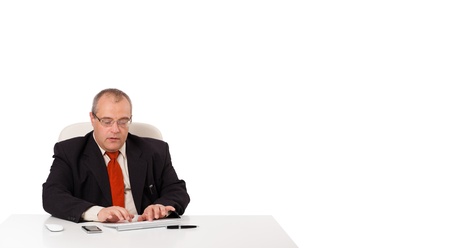 businessman sitting at desk and typing on keyboard with copy scape, isolated on whiteの写真素材