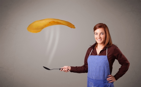 Beautiful young woman making pancakesの写真素材