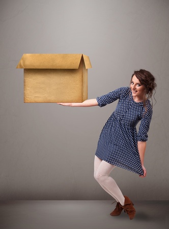 Beautiful young woman holding an empty cardboard boxの写真素材