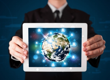 Young businessman presenting 3d earth globe in tabletの写真素材