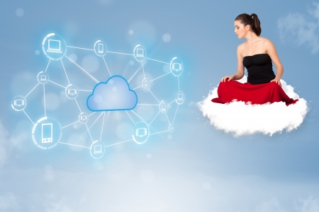 Happy young woman sitting on cloud with cloud computingの写真素材
