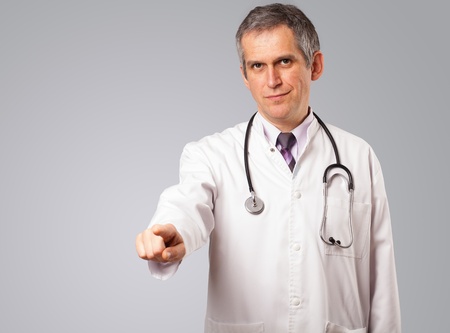Middle aged doctor standing and gesturing with copy spaaceの写真素材