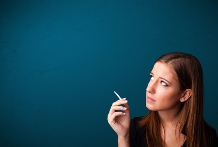 Beautiful young woman smoking cigarette with copy spaceの写真素材