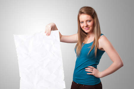 Beautiful young girl holding crumpled white paper copy spaceの写真素材