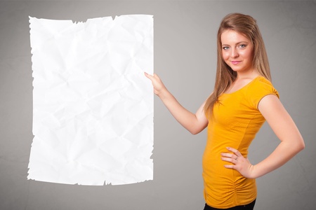 Beautiful young girl holding crumpled white paper copy spaceの写真素材