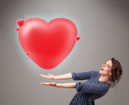 Beautiful young lady holding lovely 3d red heartの写真素材