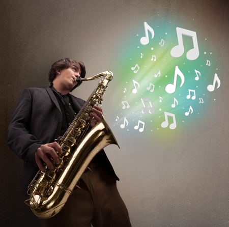 Attractive young musician playing on saxophone while musical notes explodingの写真素材