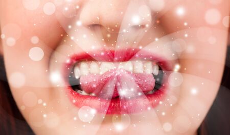 Pretty woman lips blowing abstract white lights - close upの写真素材