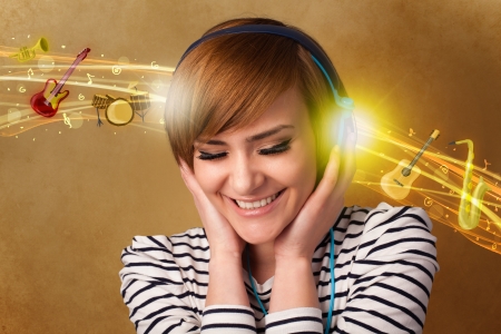 Pretty young woman with headphones listening to music, instruments conceptの写真素材