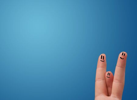 Happy smiley face fingers cheerfully looking at empty blue background copy spaceの写真素材