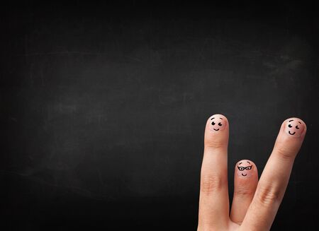 Happy cheerful smiley fingers looking at empty black chalboard