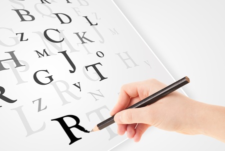 Human hand writing various letters on white plain paperの写真素材