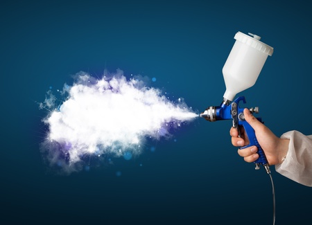Painter with airbrush gun and white magical smoke conceptの写真素材