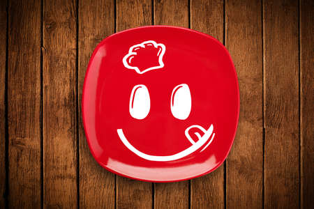 Happy smiley cartoon face on colorful dish plate and grungy backgroundの写真素材