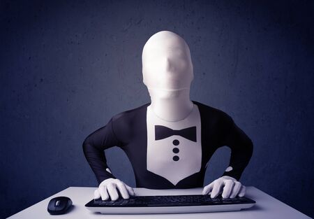 Man without identity working with keyboard and mouse on blue backgroundの写真素材