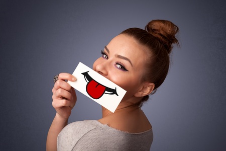 Happy pretty woman holding card with funny smiley on gradient background