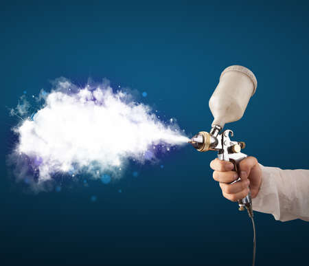 Painter with airbrush gun and white magical smoke conceptの写真素材