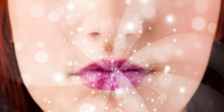 Pretty woman lips blowing abstract white lights - close upの写真素材