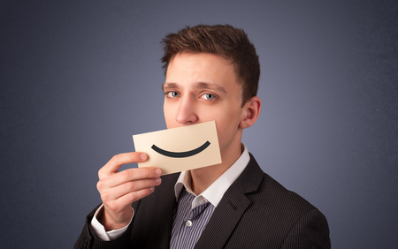 Happy businessman holding funny white card on his mouth with gradient backgroundの写真素材