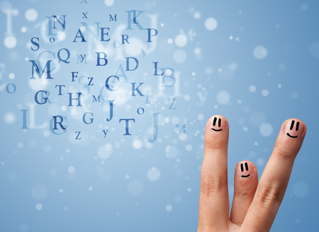 Happy cheerful smiley fingers looking at mixture of bokeh lettersの写真素材
