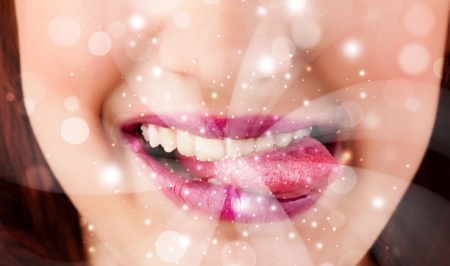 Pretty woman lips blowing abstract white lights - close upの写真素材