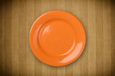 Colorful empty shiny plate on grungy background table の写真素材