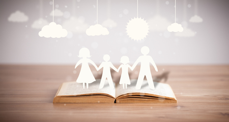 Cardboard figures of the family on opened book. The symbol of unity and happinessの写真素材