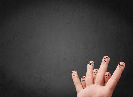 Happy finger smileys faces on hand with empty copy space dark background