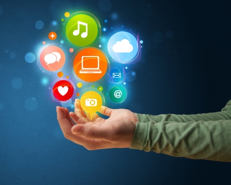 Young woman holding colorful multimedia icons in her handの写真素材