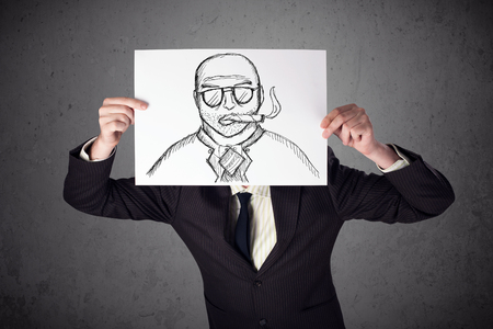 Businessman holding a cardboard with a smoking man on it in front of his headの写真素材