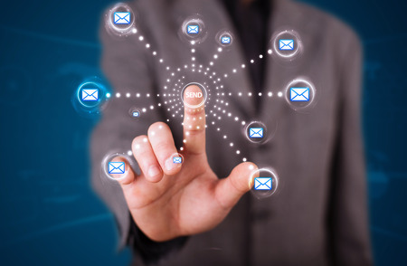 Young businessman pressing virtual messaging type of iconsの写真素材