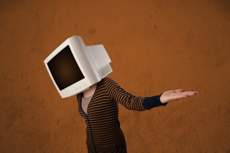 Girl with a computer monitor on her head and empty brown copyspaceの写真素材