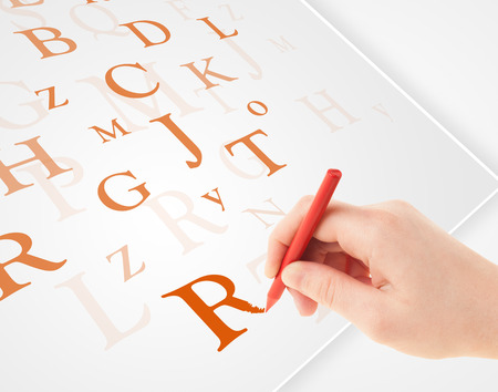 Human hand writing various letters on white plain paperの写真素材