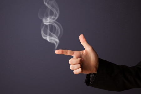 Gun shaped man hand with smokeの写真素材
